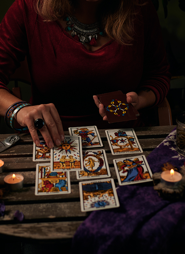 Reyyan cu cărți de tarot și lumânări sub lună plină